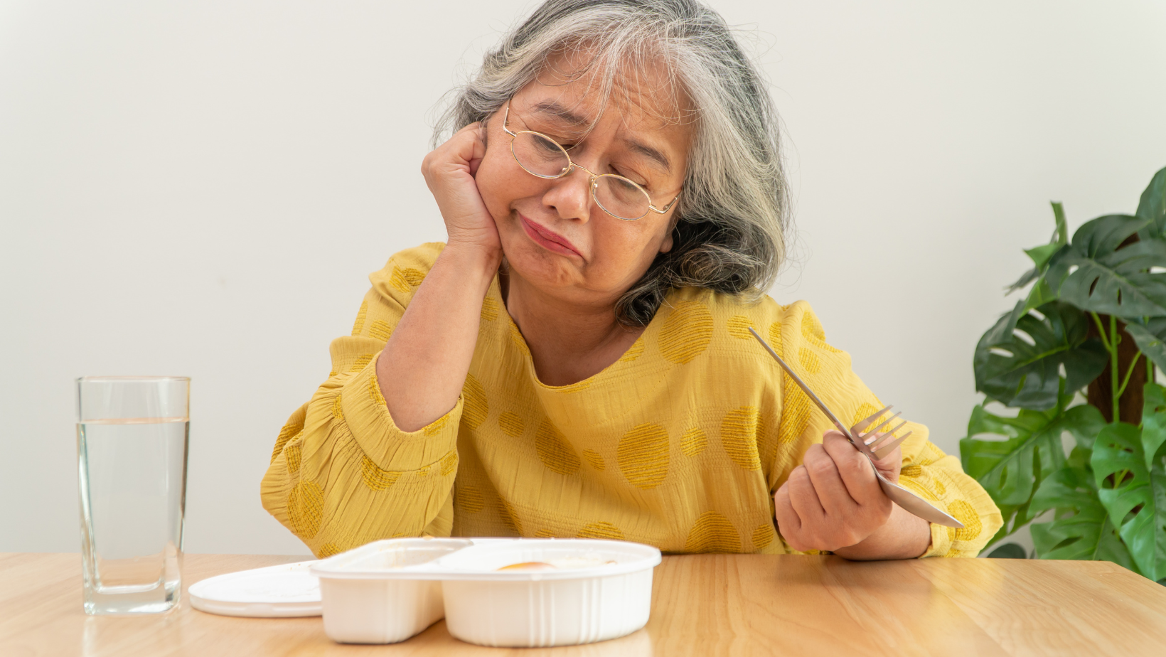 woman struggling to eat food with missing teeth