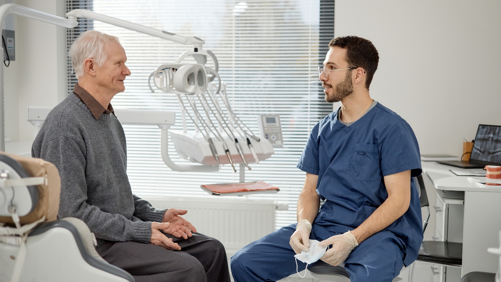 senior patient consulting dentist about dental implants in clinic